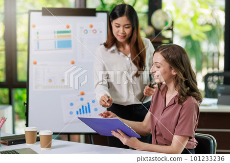 Concept of business office woman working,Businesswoman smile while working about her invesment plan with analyzing document and business investment graph data by using laptop on desk in workstation. 101233236