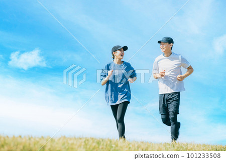 A smiling Japanese man and woman jogging under the blue sky A smiling Japanese man and woman jogging under the blue sky 101233508
