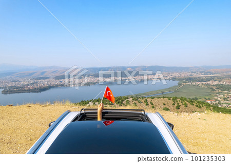 Woman holding Turkey flag from the open car sunroof, window driving along the serpentine road in the mountains. Top view. Concept Woman holding Turkey flag from the open car sunroof, window driving along the serpentine road in the mountains. Top view. Concept 101235303