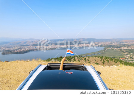Woman holding Costa Rica flag from the open car sunroof, window driving along the serpentine road in the mountains. Top view. Concept Woman holding Costa Rica flag from the open car sunroof, window driving along the serpentine road in the mountains. Top view. Concept 101235380