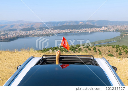 Woman holding Turkey flag from the open car sunroof, window driving along the serpentine road in the mountains. Top view. Concept Woman holding Turkey flag from the open car sunroof, window driving along the serpentine road in the mountains. Top view. Concept 101235527