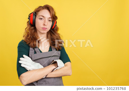 Serious redheaded female worker standing with arms crossed 101235768