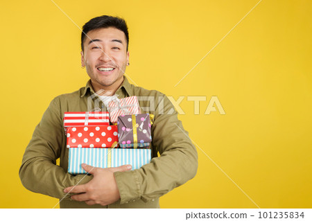 Happy chinese man holing many colorful gifts 101235834
