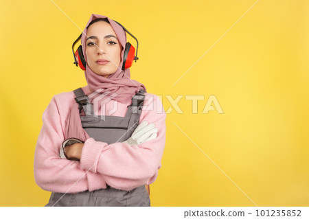 Serious muslim female carpenter in work uniform looking at camera Serious muslim female carpenter in work uniform looking at camera 101235852