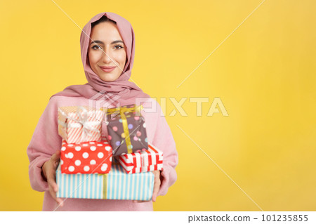 Muslim woman smiling with many gifts in the hands Muslim woman smiling with many gifts in the hands 101235855