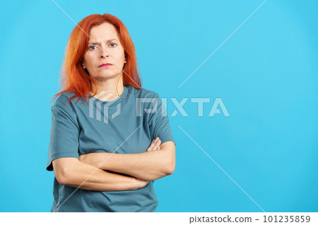 Serious mature redheaded woman looking at camera with arms crossed 101235859