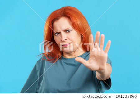 Redheaded mature woman gesturing prohibition with hand 101235860