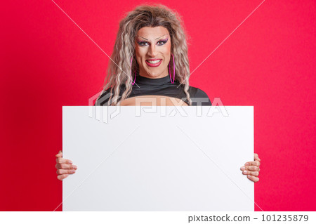 Smiley transgender person holding a blank panel in studio 101235879