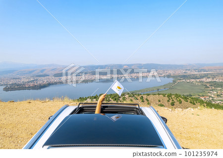 Woman holding Cyprus flag from the open car sunroof,  window driving along the serpentine road in the mountains. Top view. Concept 101235974