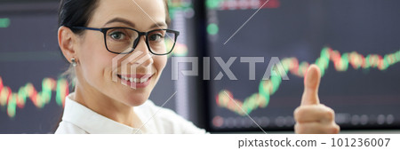 Happy woman trader showing thumb up gesture 101236007