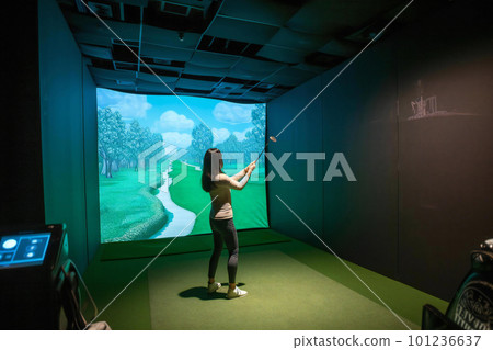 woman playing simulation golf woman playing simulation golf 101236637