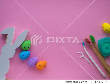 Wooden toothbrushes with Easter decorations on pink background Wooden toothbrushes with Easter decorations on pink background 101237293
