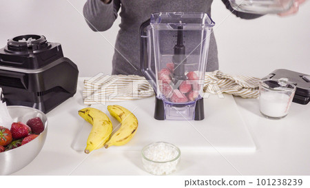 Preparing strawberry and banana smoothie in the kitchen blender. Preparing strawberry and banana smoothie in the kitchen blender. 101238239