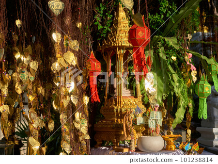 Thai Buddha altar, offerings, lanterns, golden leaves of Bodhi tree.  101238814