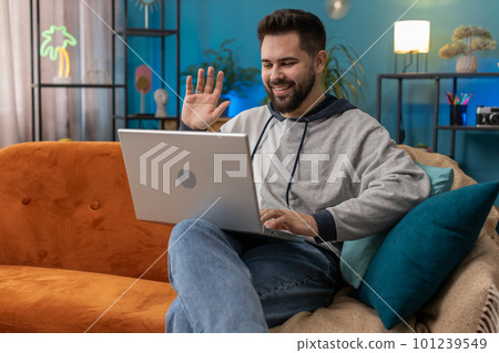 Man sitting on home couch, looking at camera, making video conference call with friends or family Man sitting on home couch, looking at camera, making video conference call with friends or family 101239549