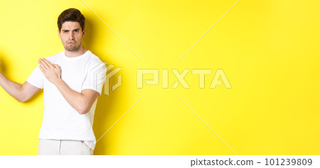 Man showing kung-fu skills, martial arts ninja movement, standing in white t-shirt ready to fight, standing over yellow background Man showing kung-fu skills, martial arts ninja movement, standing in white t-shirt ready to fight, standing over yellow background 101239809