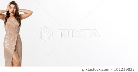 Christmas party and celebration concept. Full length of beautiful brunette woman looking surprised, wearing elegant dressed and staring with disbelief at camera, white background Christmas party and celebration concept. Full length of beautiful brunette woman looking surprised, wearing elegant dressed and staring with disbelief at camera, white background 101239822