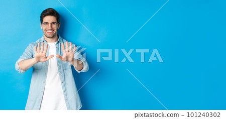 Image of smiling man looking satisfied at his manicure, visit beauty salon, standing over blue background Image of smiling man looking satisfied at his manicure, visit beauty salon, standing over blue background 101240302