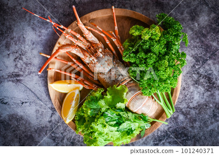 fresh lobster or rock lobster seafood with herb and spices lemon coriander parsley lettuce salad, spiny lobster food on plate, lobster for cooking food and seafood sauce fresh lobster or rock lobster seafood with herb and spices lemon coriander parsley lettuce salad, spiny lobster food on plate, lobster for cooking food and seafood sauce 101240371