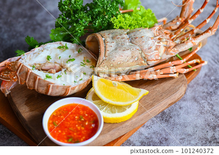 fresh lobster or rock lobster seafood with herb and spices lemon coriander parsley lettuce salad, spiny lobster food on plate, lobster for cooking food and seafood sauce 101240372