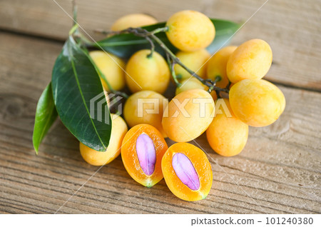 Marian plum fruit and leaves in plate on wooden background, tropical fruit Name in Thailand Sweet Yellow Marian Plum Maprang Plango or Mayong chid 101240380