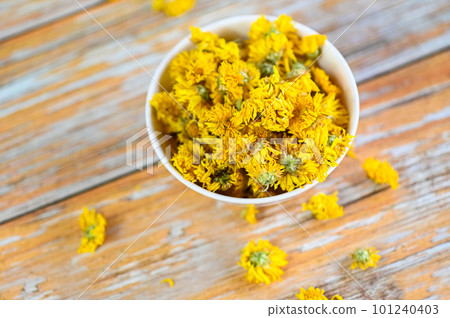Chinese chrysanthemum flower tea - Dried chrysanthemum buds for herbal tea on wooden background, dry chrysanthemum flower yellow Chinese chrysanthemum flower tea - Dried chrysanthemum buds for herbal tea on wooden background, dry chrysanthemum flower yellow 101240403