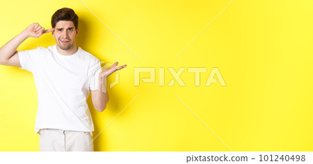 Confused and angry man pointing at head, scolding person for acting stupid, show crazy sign, standing over yellow background Confused and angry man pointing at head, scolding person for acting stupid, show crazy sign, standing over yellow background 101240498