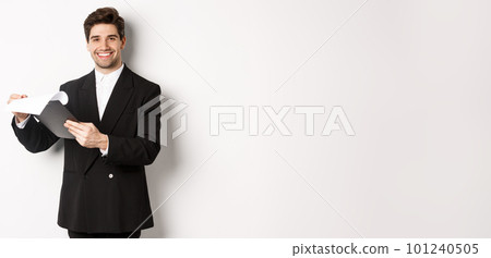 Image of confident businessman in suit looking at documents, holding clipboard and smiling pleased, standing against white background Image of confident businessman in suit looking at documents, holding clipboard and smiling pleased, standing against white background 101240505