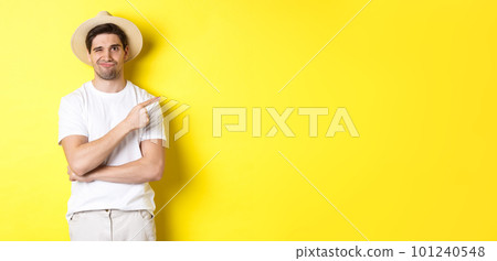 Skeptical male tourist complaining, pointing finger right at something bad or lame, standing unamused against yellow background Skeptical male tourist complaining, pointing finger right at something bad or lame, standing unamused against yellow background 101240548