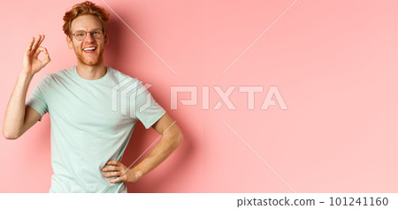Cheerful guy with red hair and beard, wearing glasses, showing OK sign in approval and saying yes, smiling satisfied, standing over pink background Cheerful guy with red hair and beard, wearing glasses, showing OK sign in approval and saying yes, smiling satisfied, standing over pink background 101241160