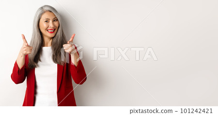 Professional female employer in trendy red blazer and makeup, pointing fingers at camera and smiling, praising something, need you, standing over white background Professional female employer in trendy red blazer and makeup, pointing fingers at camera and smiling, praising something, need you, standing over white background 101242421