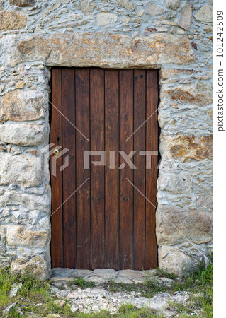 Old wooden door and stone wall 101242509