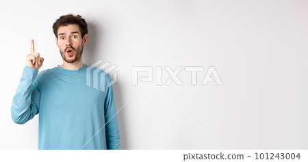 Image of excited handsome man pitching an idea, raising finger and saying eureka, standing over white background 101243004