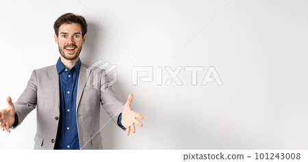 Happy handsome man in suit stretch out hands to greet business partners, welcome guests and smiling excited, standing on white background Happy handsome man in suit stretch out hands to greet business partners, welcome guests and smiling excited, standing on white background 101243008