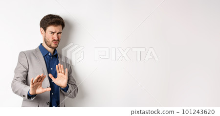 Stay away. Reluctant businessman step back with concerned disgusted face, raising hands to block bad offer, rejecting something awful, telling no and decline proposal, white background 101243620