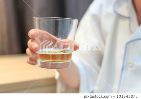 Woman drinking beer in hotel room Woman drinking beer in hotel room 101243875