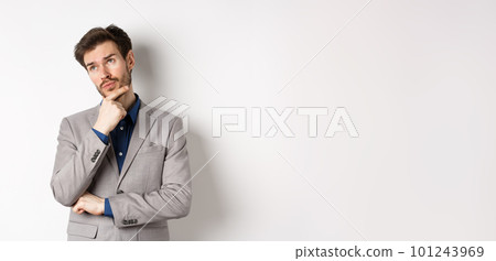 Thoughtful businessman in grey suit look at upper left corner logo, thinking or making choice, pondering plan, standing against white background 101243969