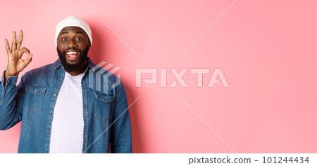 Happy smiling Black guy showing okay sign, approve and praise good offer, standing over pink background Happy smiling Black guy showing okay sign, approve and praise good offer, standing over pink background 101244434
