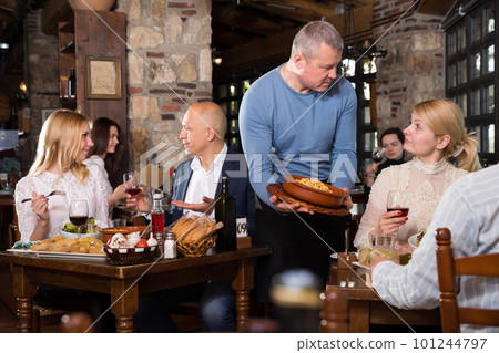 Male waiter carrying order for visitors in country restaurant Male waiter carrying order for visitors in country restaurant 101244797