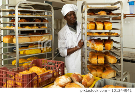 African baker carrying fresh bread on trolley 101244941