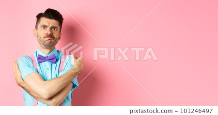 Timid guy embracing own body, comforting himself and looking offended, sulking at you, standing insulted and sad on pink background Timid guy embracing own body, comforting himself and looking offended, sulking at you, standing insulted and sad on pink background 101246497