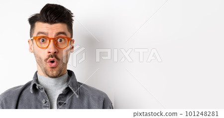 Wow look there. Excited handsome man in stylish glasses stare impressed at camera, checking out eyewear store offer, standing on white background 101248281