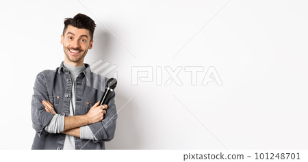 Handsome caucasian guy with moustache cross arms on chest, holding mic and smiling at camera, perform on stage with microphone, standing against white background 101248701