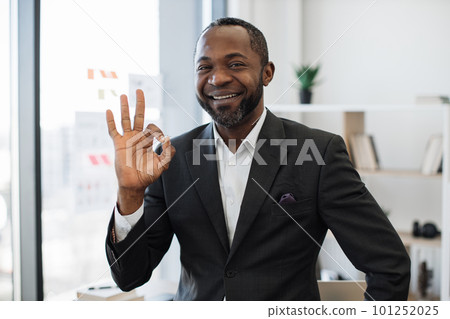 Man in formal attire smiling at camera at office 101252025