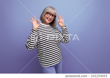 middle-aged business woman with gray hair cheerfully posing against a bright studio background 101254055