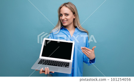 cute blond girl with a laptop in her hands with a mocup on a blue background cute blond girl with a laptop in her hands with a mocup on a blue background 101254056