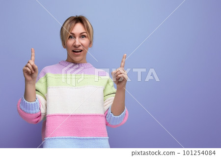 bright cute blondie woman showing copy space on purple background 101254084