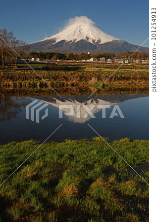 Upside-down Mt.Fuji covered with haze-like clouds on the summit reflected on the surface of the water Upside-down Mt.Fuji covered with haze-like clouds on the summit reflected on the surface of the water 101254913