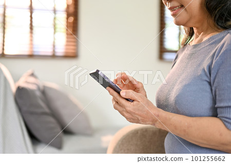 Close-up image of a happy Asian-aged woman using her smartphone 101255662