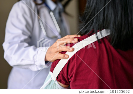 An orthopedic doctor touching a patient's shoulder to comfort and reassure. 101255692